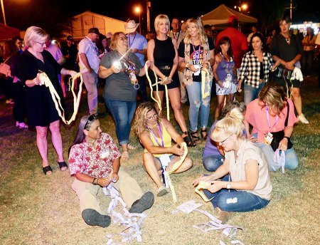 Over 700 grads attend Lemoore High 1980's All-Classes Reunion Saturday night Classmates look over silent auction tickets.